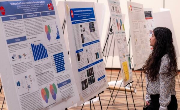 A student learns about the research presented during the poster session at the fourth annual CBQB Research Day.